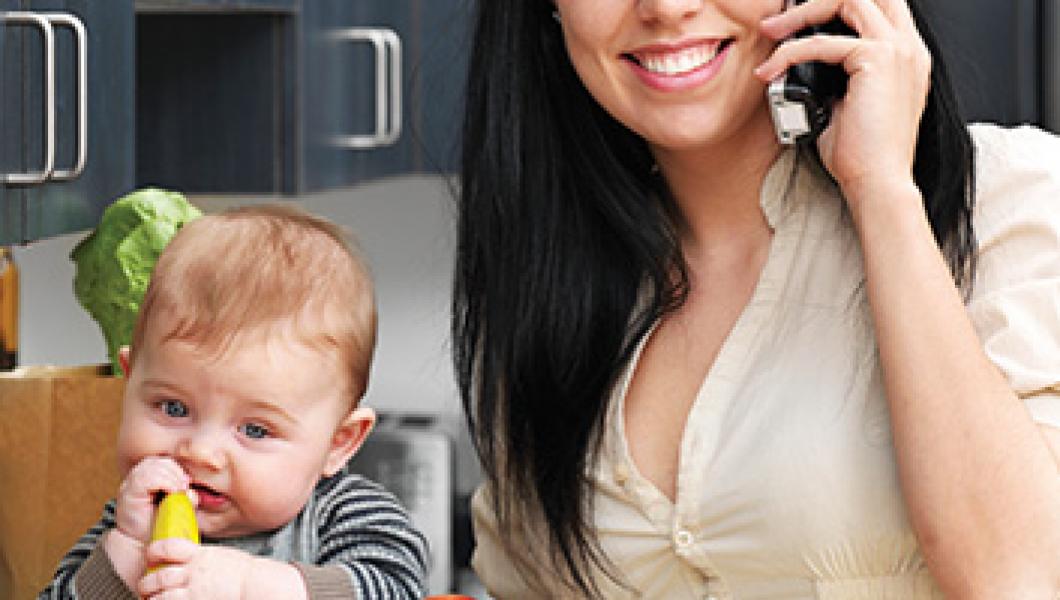 mother on phone next to infant