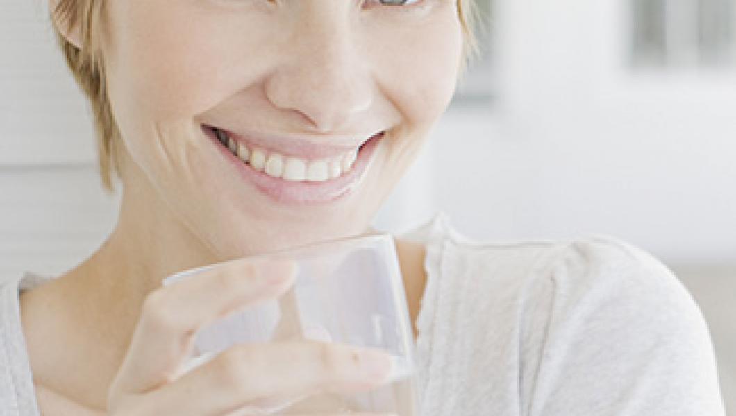 woman smiling drinking water