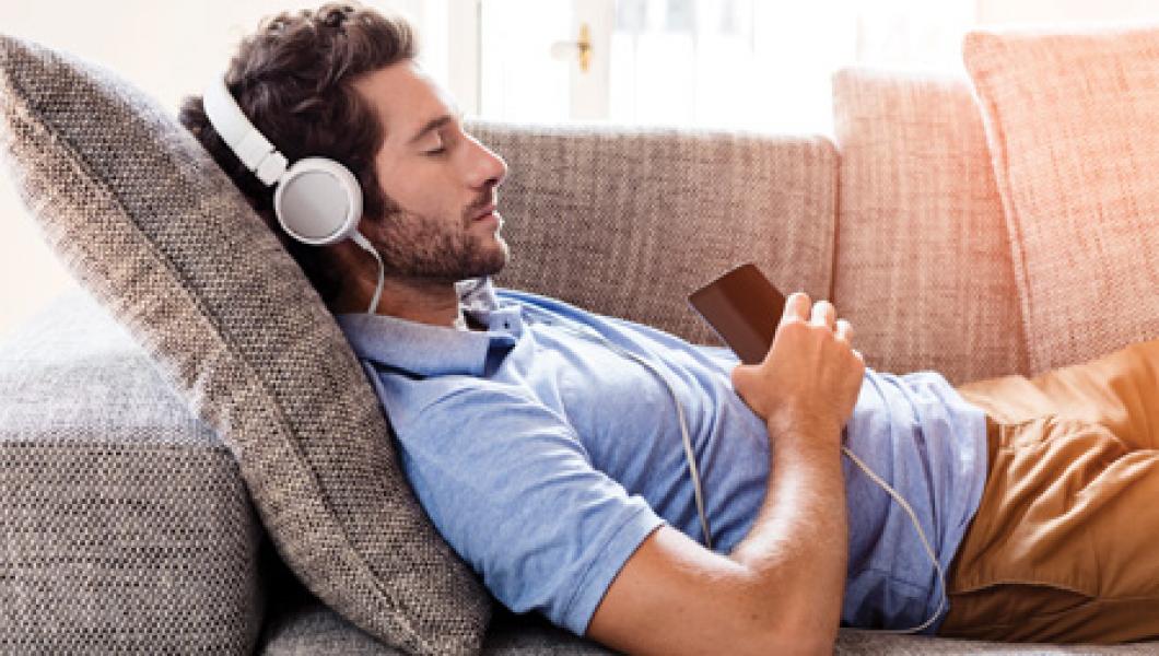 Man with headphones relaxing on sofa