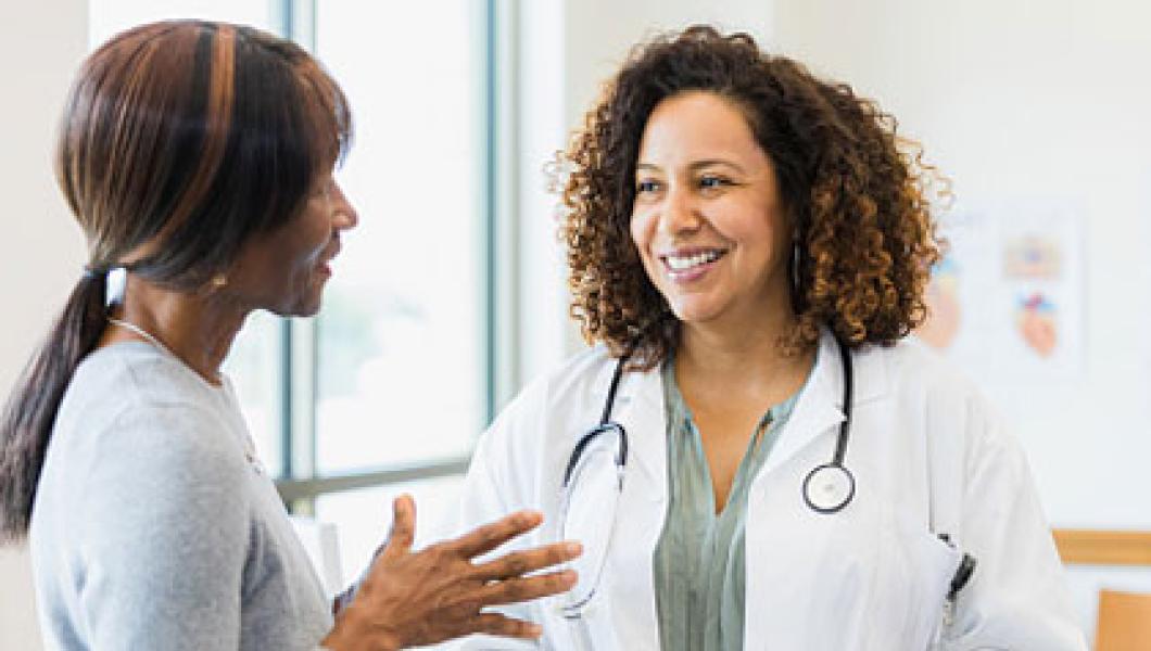 african american female doctor smiling and speaking with a patient