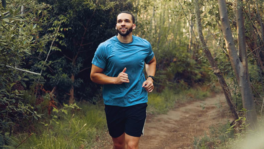 Man jogging down wooded path