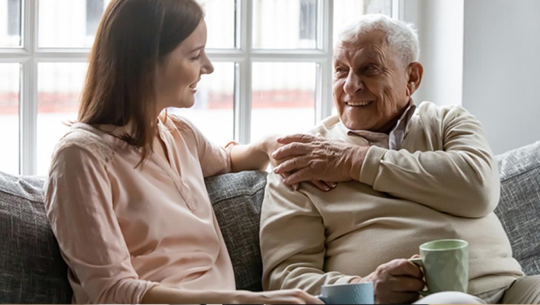 young woman sitting on couch with elderly gentleman