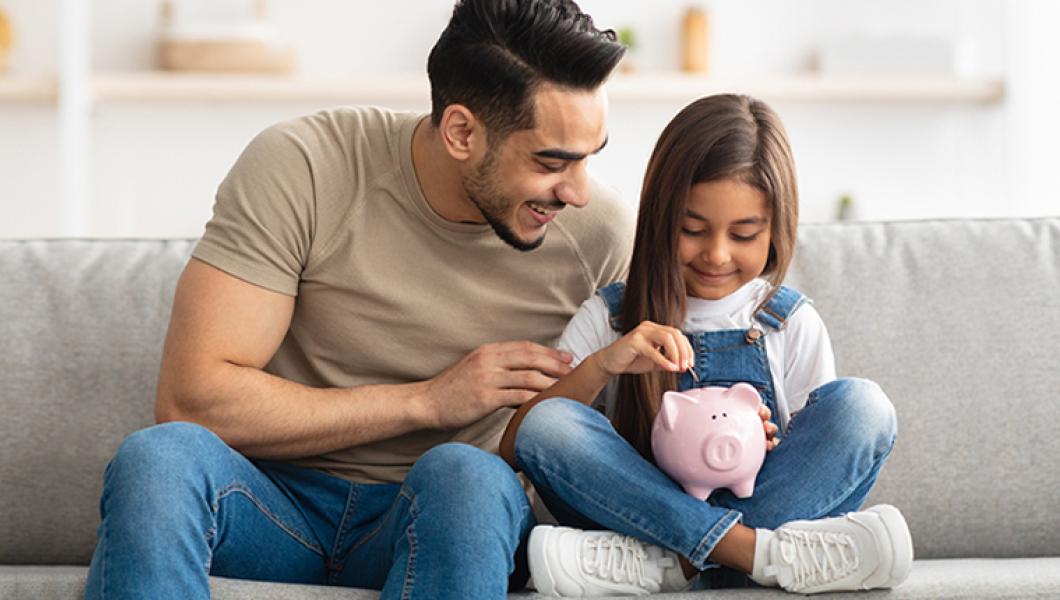 father teaching daughter to save money