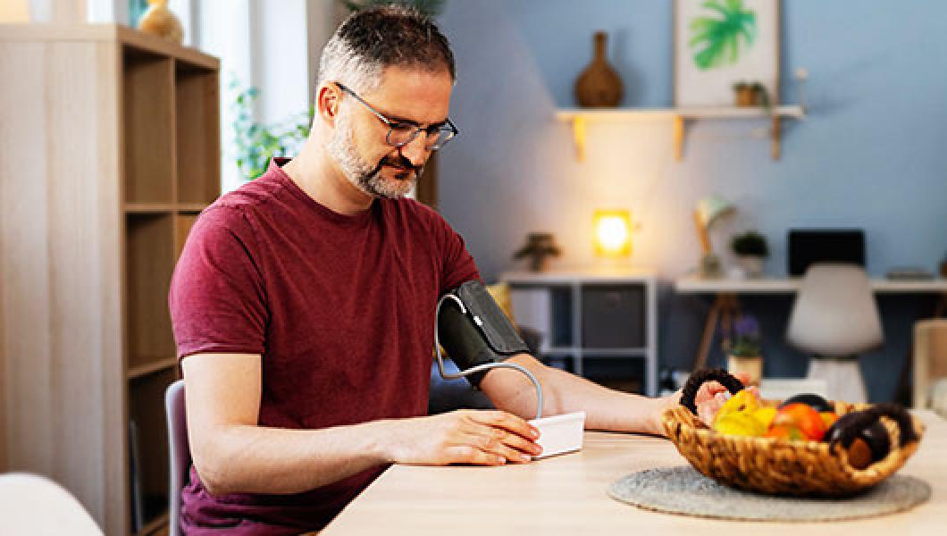 Man checking his blood pressure at home