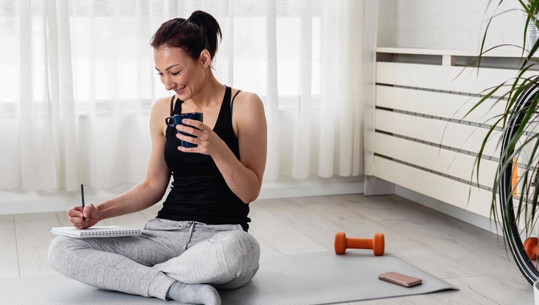 Woman drinking tea working out at home