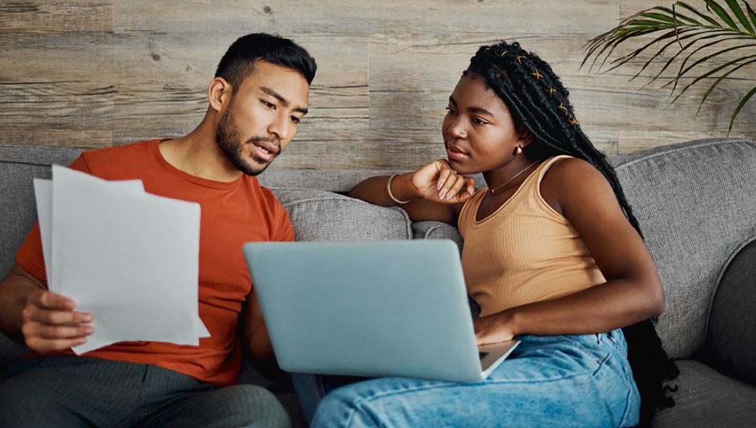 Young couple looking over paperwork on sofa