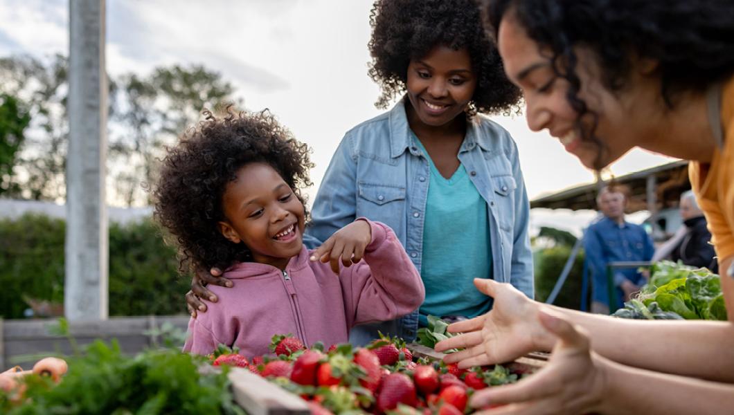 Mother and daughter choosing vegetables at farmer's market
