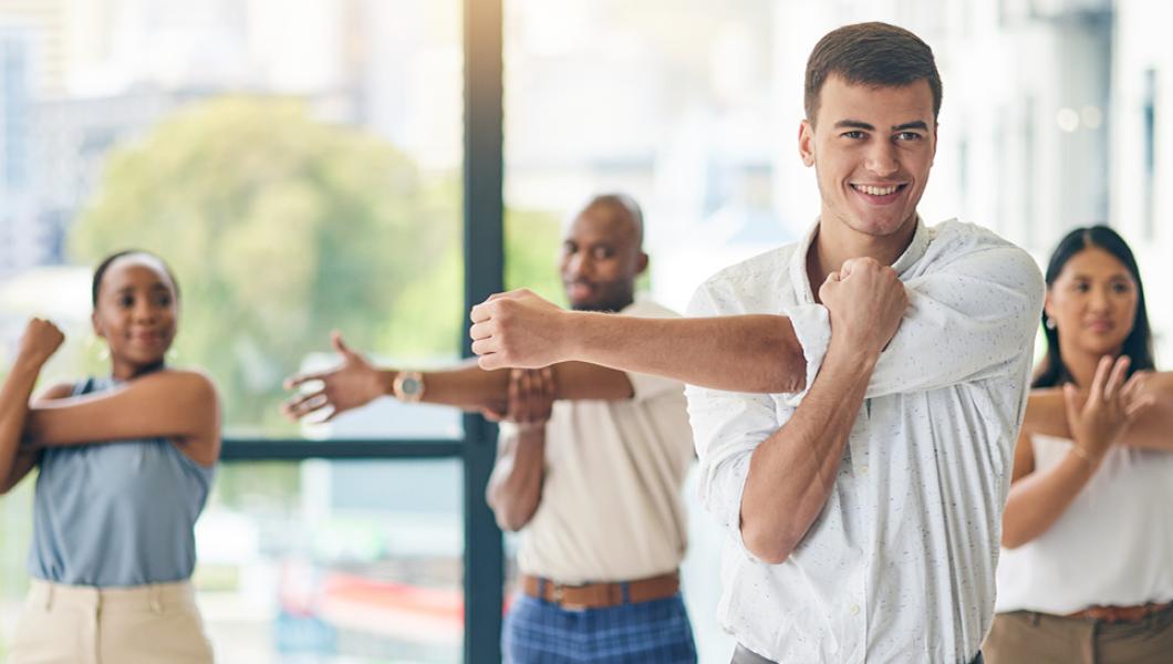 Co-workers stretching at the office