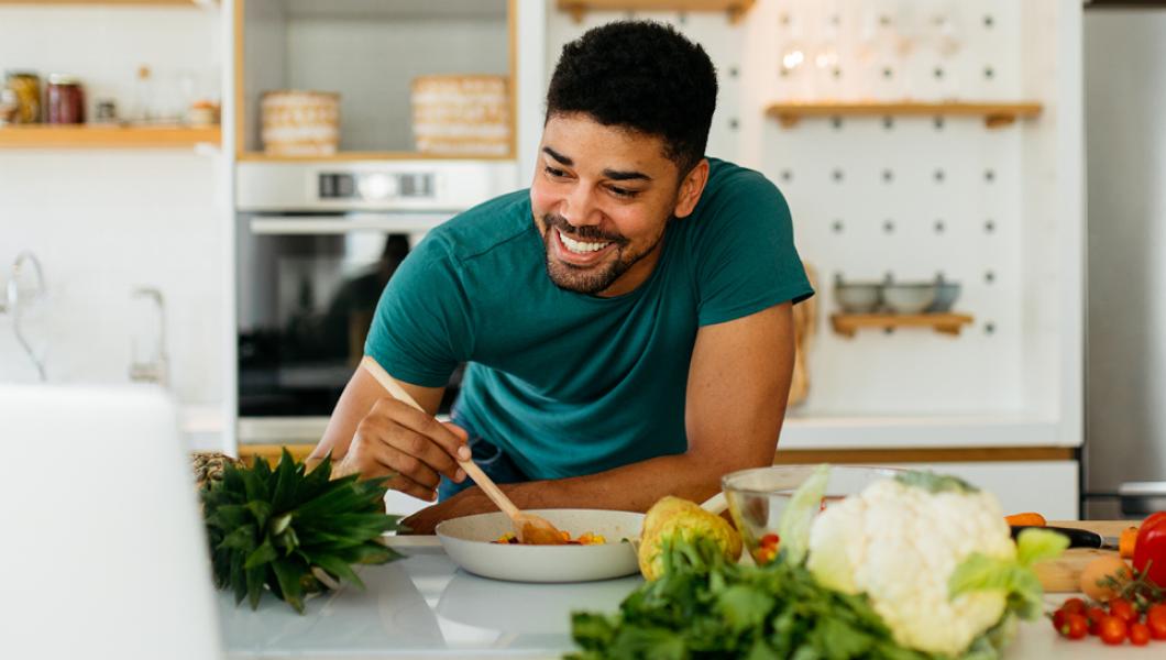 Man eating salad in kitchen
