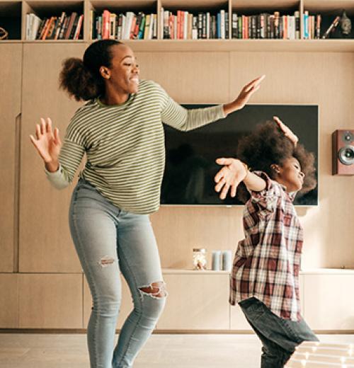 mother and daughter dancing in living room