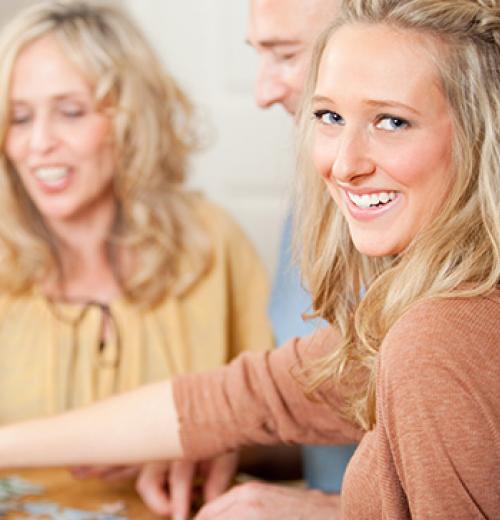 young woman smiling playing game with family