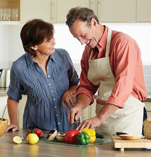 mature couple chopping vegetables