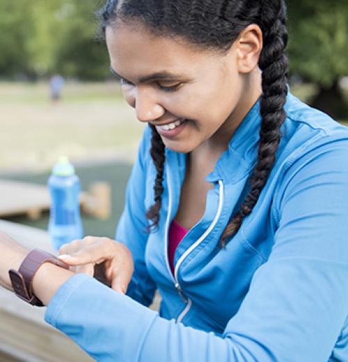 smiling woman checking fitness tracker