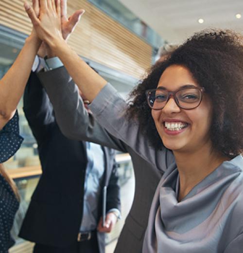 smiling woman high-fiving coworkers