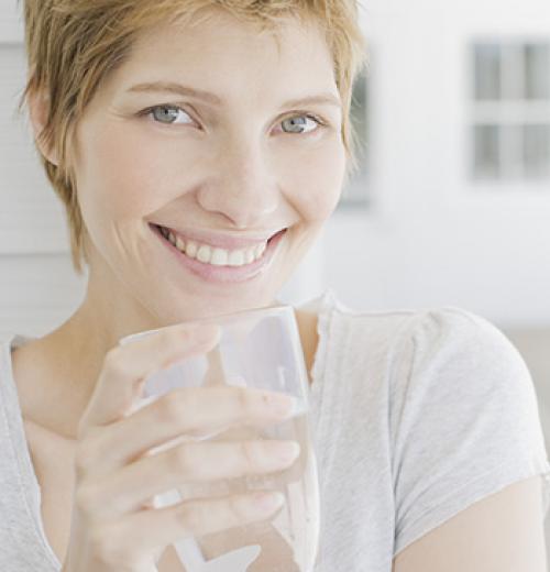 woman smiling drinking water