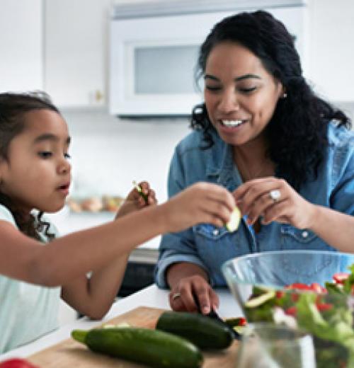 mother and daughter in kitchen with vegetables