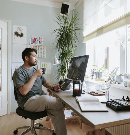 man with coffee at home office