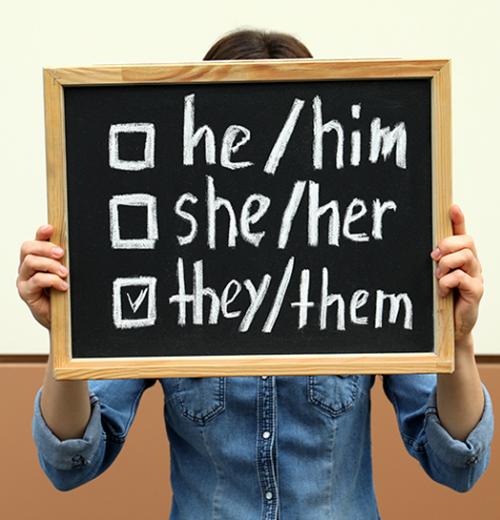 Person holding sign with pronoun choices