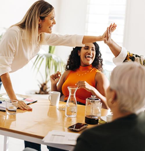 coworkers high fiving in meeting