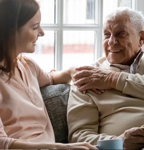 young woman sitting on couch with elderly gentleman