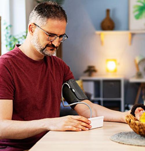 Man checking his blood pressure at home