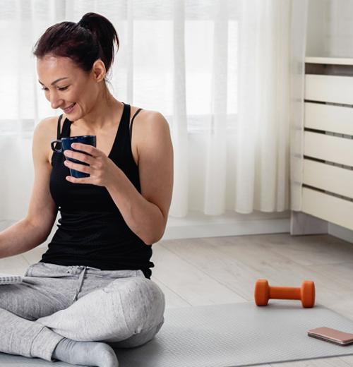 Woman drinking tea working out at home