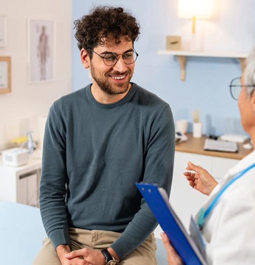 Young adult male talking with doctor