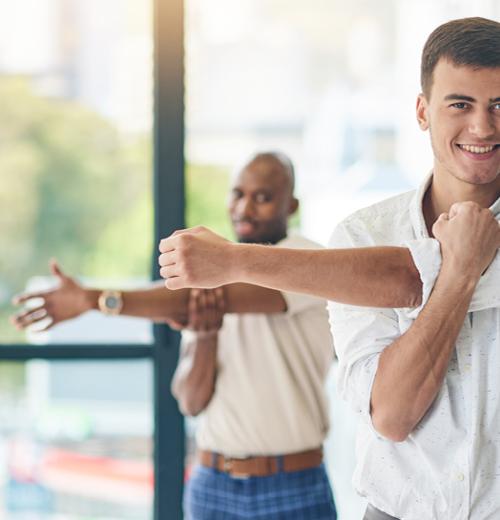 Co-workers stretching at the office
