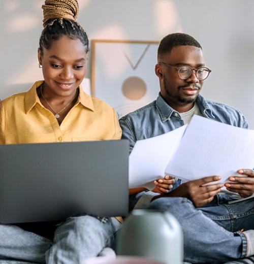 Couple sitting on sofa working on budget together